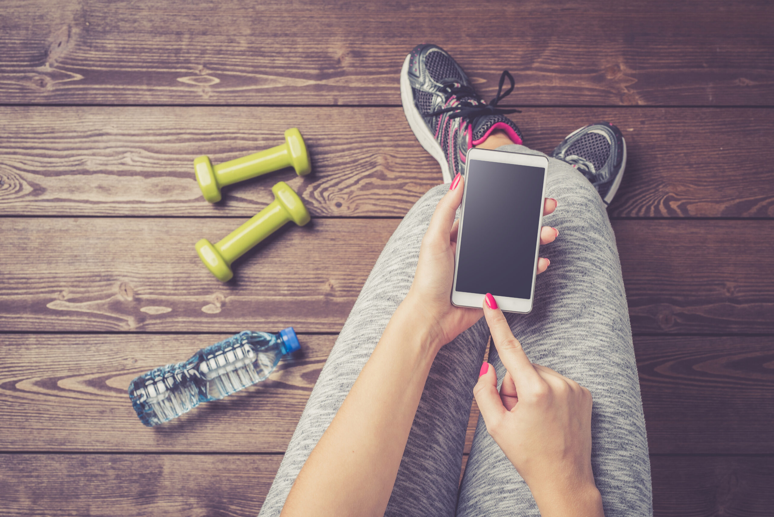 Person in workout clothes using iPhone